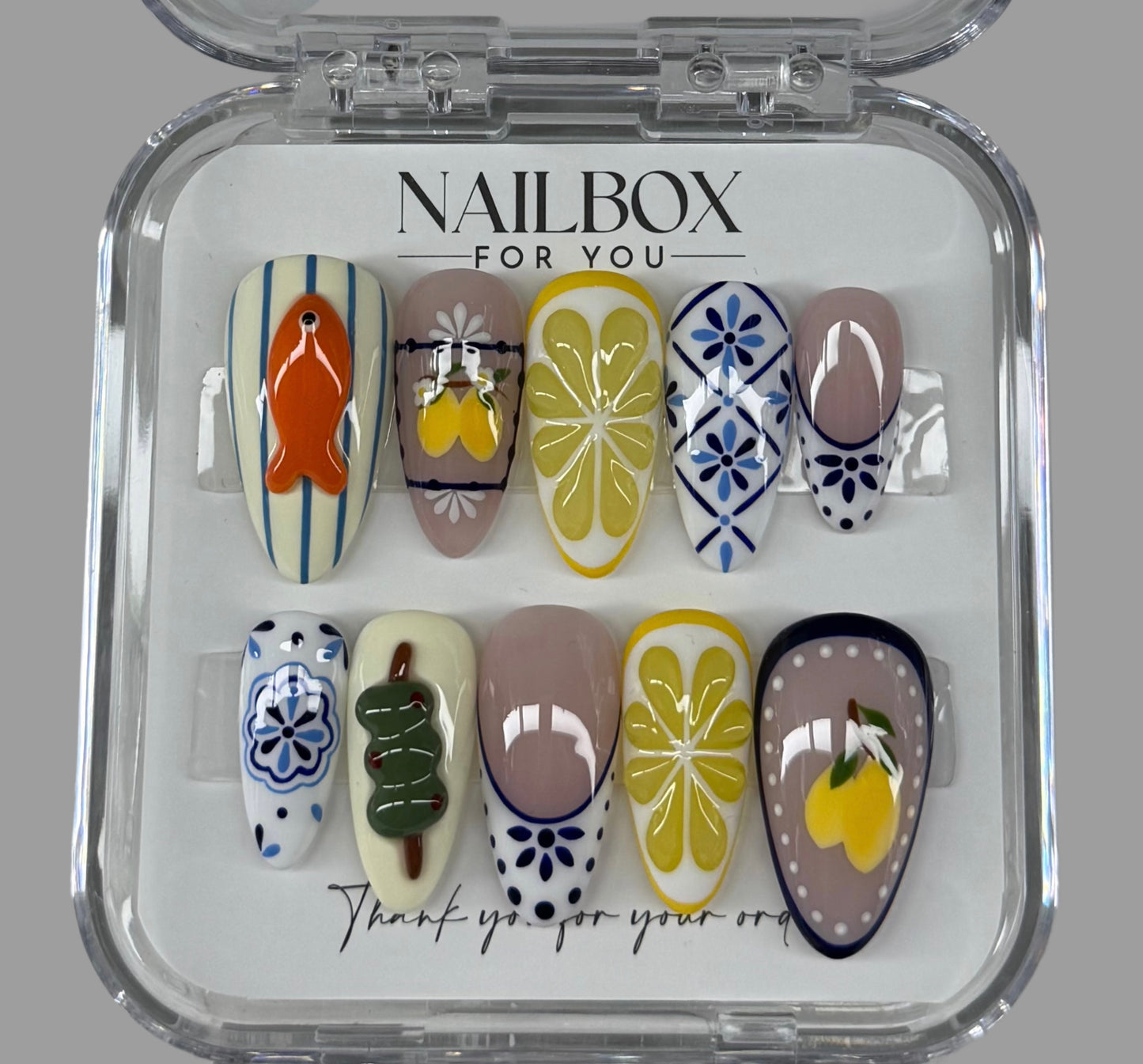 Nail art display with various designs in a clear case labeled 'Nailbox for You'.