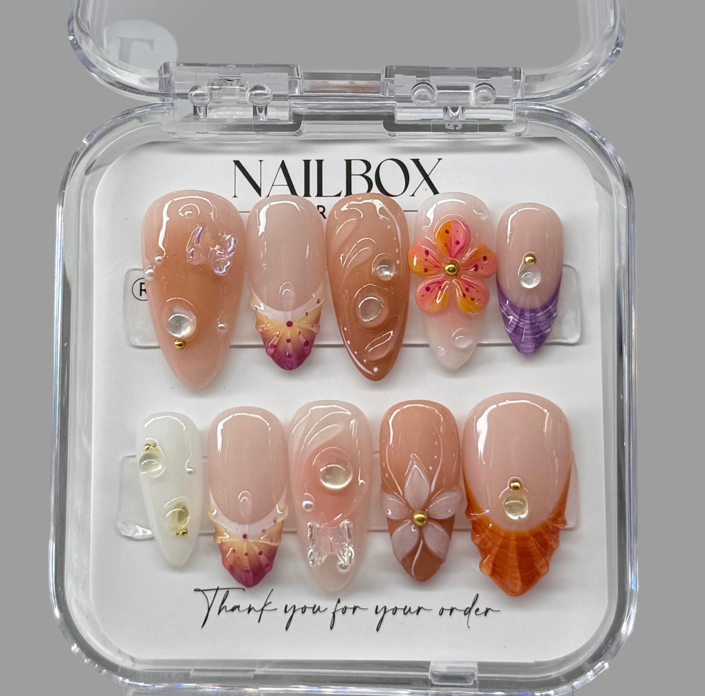 Nail art set in a clear box with 'NAILBOX' branding on a gray background