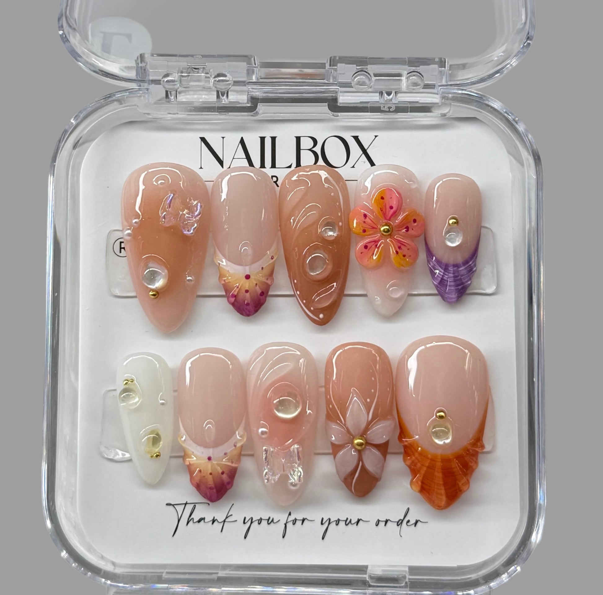 Nail art set in a clear box with 'NAILBOX' branding on a gray background