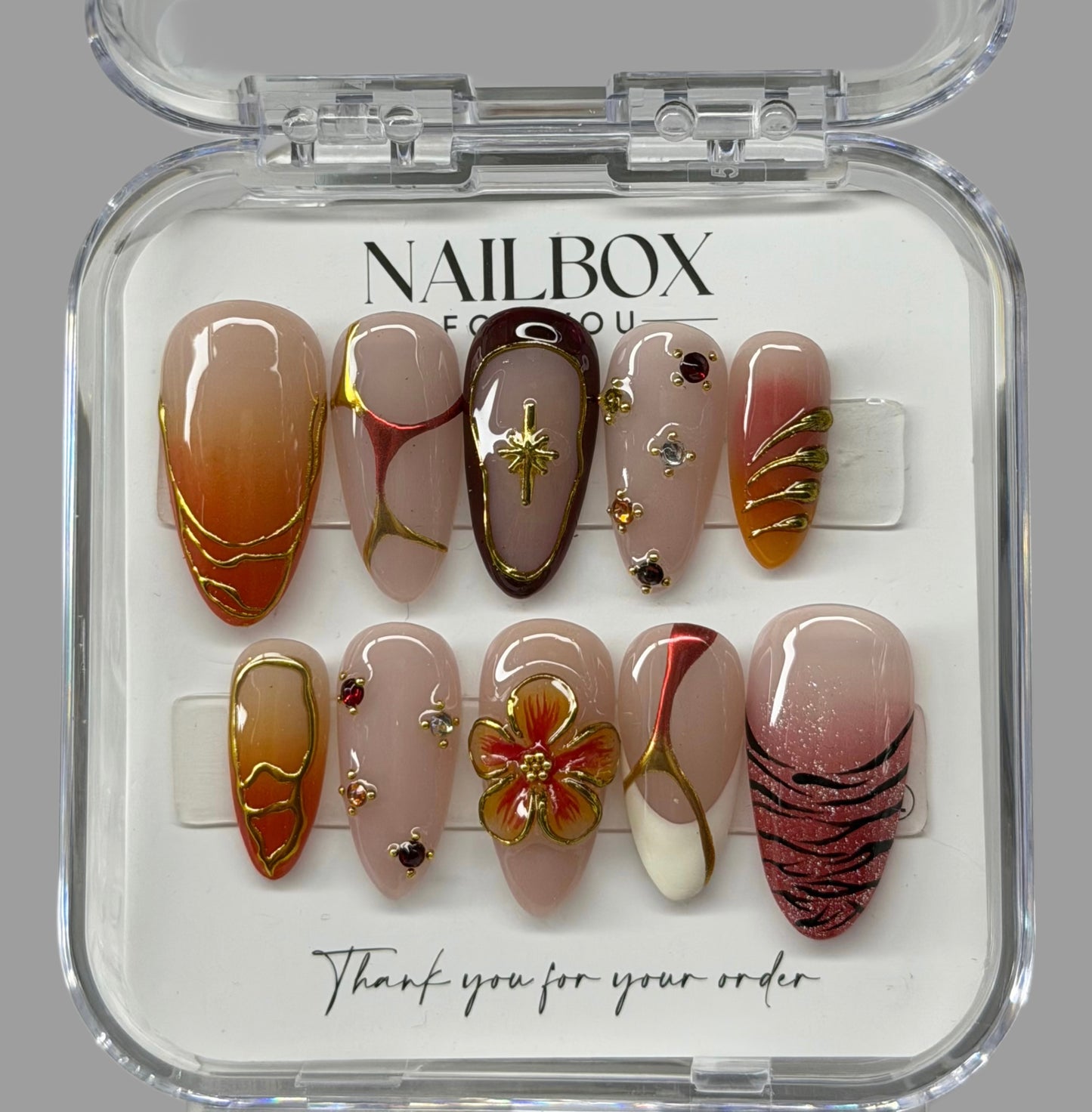 Set of nail art designs in a clear Nailbox packaging on a gray background